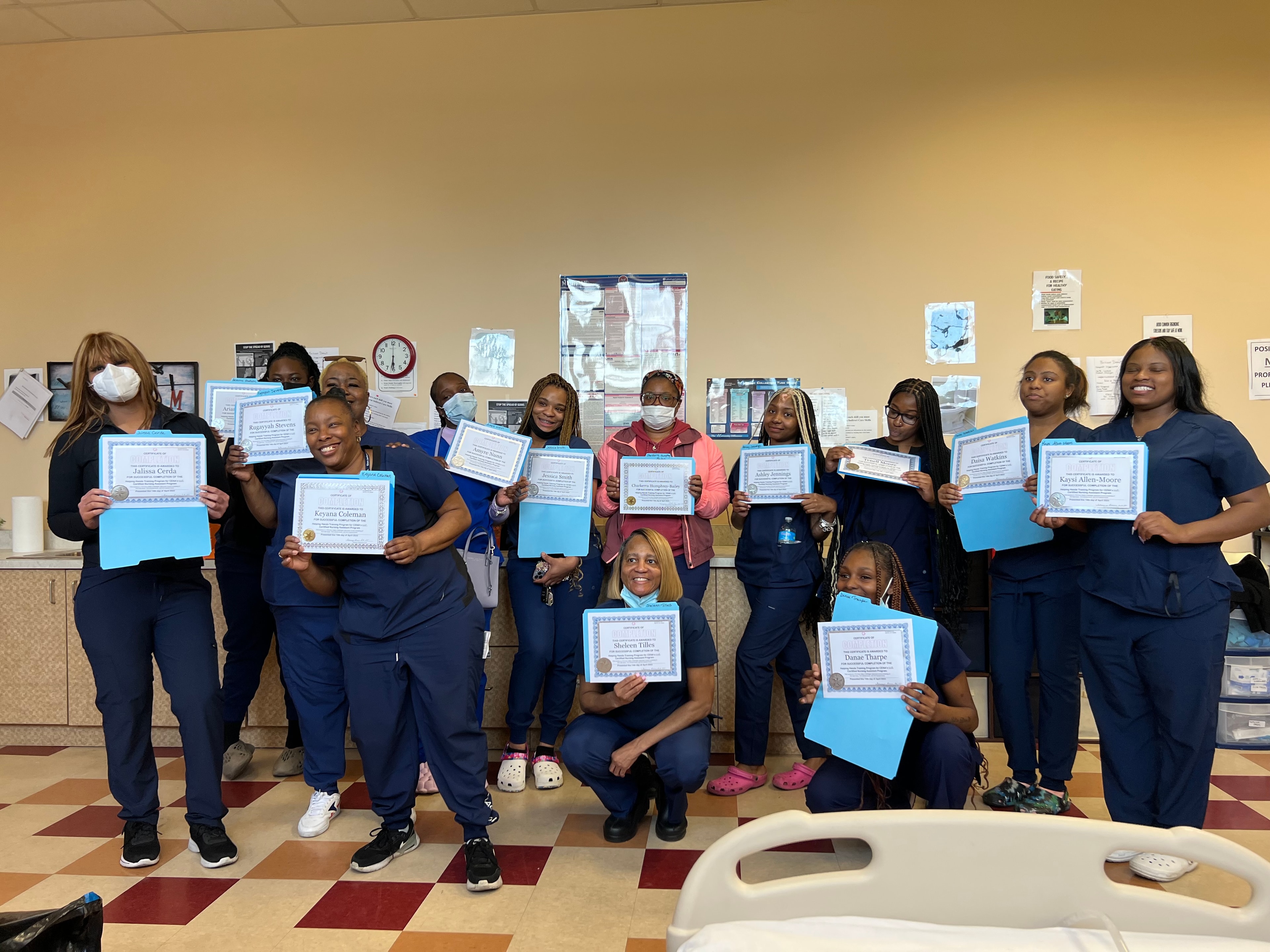 Helping Hands CNA graduates with completion certificates in classroom